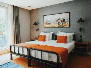 a hotel room with two beds and a painting on the wall at Hotel Poem in Istanbul