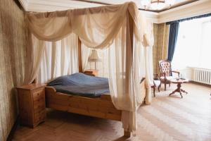 a bedroom with a canopy bed in a room at Jaunpils pils in Jaunpils
