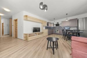 ein Wohnzimmer und eine Küche mit einer Couch und einem Tisch in der Unterkunft Air-conditioned 2-bedroom apartment, balcony, Závadská-Rača in Rača + 15 Fotos