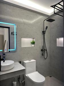 ein Badezimmer mit einer weißen Toilette und einem Waschbecken in der Unterkunft Fovahi Shark View Inn in Fuvahmulah + 14 Fotos