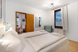 two beds in a white room with a window at Ferienwohnung Strandquartier in Travemünde