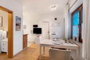a white dining room with a white table and chairs at Ferienwohnung Strandquartier in Travemünde