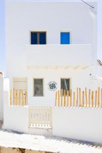 a white house with a fence and chairs at Elaia Home luxury village apartment for two Naxos in Galini