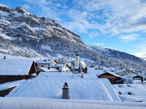 Mygrischa في فليمس: قريه مغطاه بالثلوج مع جبل في الخلف