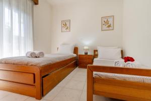 two beds in a room with white walls at Mike's House in Kremasti near the Beach Rhodes in Kremasti +52 photos