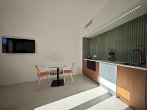 een keuken met een tafel en twee stoelen en een tv bij Viva Riviera Design and Sunny Commandant André in Cannes