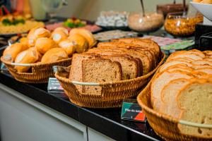 a counter with baskets of bread and other foods at Hotel Sagres Praia in Balneário Camboriú +18 photos