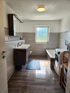 a bathroom with a sink and a washing machine at Beim Mooswiesler Dahoam in Polling +14 photos