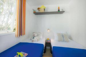 a bedroom with two beds and a teddy bear sitting on the bed at Camping Cœur de Vendée in La Boissière-de-Montaigu
