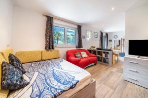 Un dormitorio con una cama grande y una silla roja. en Haus Reimon Apt Monika, en San Leonardo in Passiria