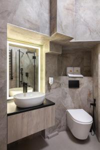 a bathroom with a sink and a toilet and a mirror at Royal jacuzzi apartment on Krehivska 10 st in Lviv