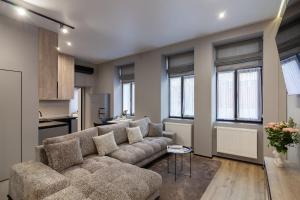 a living room with a couch and some windows at Royal jacuzzi apartment on Krehivska 10 st in Lviv