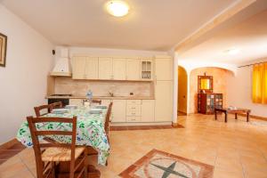 カーラ・リベロットにあるAppartamento Cuoreのテーブルと椅子のあるキッチンとダイニングルーム +15枚の写真