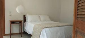 a bed with white sheets and pillows in a room at Estalagem Angu Duro in São Gonçalo do Rio das Pedras