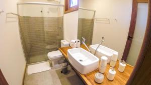 a bathroom with a sink and a toilet and a shower at Estalagem Angu Duro in São Gonçalo do Rio das Pedras