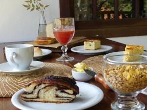 a table with plates of bread and a glass of wine at Estalagem Angu Duro in São Gonçalo do Rio das Pedras +4 photos