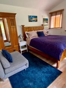 a bedroom with a purple bed and a chair at Little Cabin in Middlepoint in Halfmoon Bay
