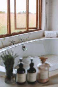 カリナンにあるButjani Lodgeの窓と2本のボトルが付いたバスルームのシンク