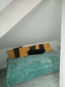 a bed with colorful pillows on it in a room at Chambre pour une personne in Blois
