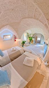 a large room with two beds in a stone wall at Al Palazzotto in Fasano