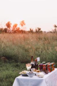 カリナンにあるButjani Lodgeのビール瓶と食べ物が置かれたテーブル +5枚の写真