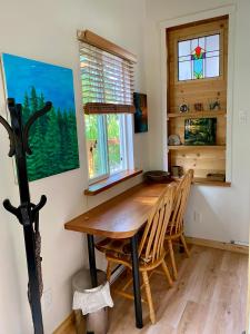 a dining room with a wooden table and chairs at Little Cabin in Middlepoint in Halfmoon Bay +22 photos