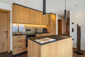 StullesにあるSunnseitn Lodge Exclusive Panoramaのキッチン(木製キャビネット、黒いカウンタートップ付) +11枚の写真