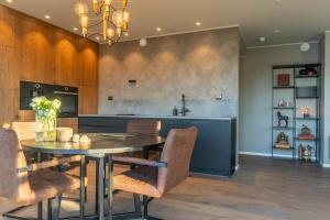 Una cocina y un comedor con mesa y sillas. en Lofoten Oceanfront Panoramic, en Kabelvåg