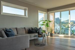 una sala de estar con un sofá y una mesa en Lofoten Oceanfront Panoramic, en Kabelvåg 33 fotos más