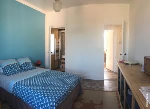 a bedroom with a blue bed and a hallway at La Ptite Fabrique chez Malot in Montceau-les-Mines