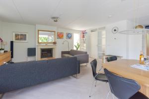 ein Wohnzimmer mit Sofa und Tisch in der Unterkunft Duinvilla Deluxe met Sauna en Whirpool - 6 personen in Holle Poarte