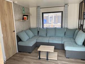 a living room with a blue couch and a table at Ferienhaus im Naturschutzgebiet in Holland in Lauwersoog