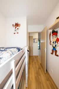 une chambre avec un lit superposé et une fresque murale de pirates dans l'établissement Gîte Le Parmé' nid 3 lits parking privé terrasse, à Beaucroissant