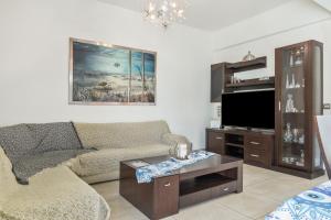 a living room with a couch and a tv at Mouria House in Kithnos