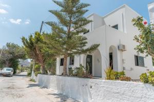 a house with a pine tree in front of it at Mouria House in Kithnos