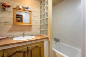 a bathroom with a sink and a mirror and a tub at Chalet Lou Murgis in Saint-Sorlin-dʼArves