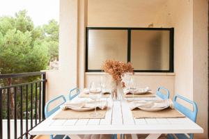 a white table with a vase of flowers on a balcony at Apartamento La Cala Azul en Miami in Miami Platja