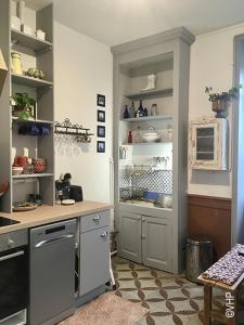 a kitchen with a stove and a refrigerator at La Ptite Fabrique chez Malot in Montceau-les-Mines