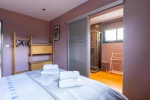 a bedroom with a bed with two towels at Lumineux - parking - wifi - clim - 3 lits dont 1 King size - jardin- in Mont-de-Marsan +10 photos