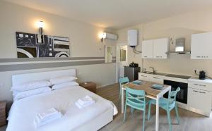 a bedroom with a bed and a table and a kitchen at City Loft in Piacenza