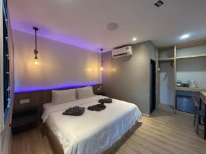 邦咯Alva Boutique Chalet Pangkor的一间卧室配有白色床,上面有紫色的灯 更多16张照片