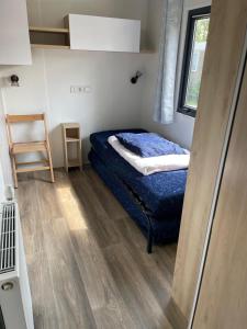 a small bedroom with a bed and a window at Ferienhaus im Naturschutzgebiet in Holland in Lauwersoog