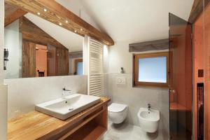 une salle de bain avec un lavabo, des toilettes et un miroir dans l'établissement Steineggerhof, à Valle Di Casies 67 autres photos