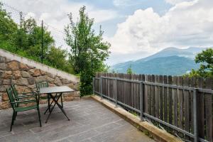 Una mesa y una silla en un patio con montañas. en Haus Pferscher, en Barbiano