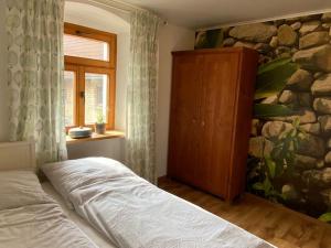 LeibertingenにあるAltes Rathausのベッドと石の壁のある寝室