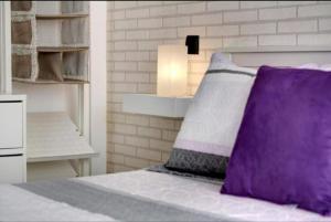 una camera con letto e cuscino viola di Magara suites Las Canteras a Guanarteme