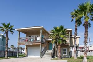ein Haus mit Palmen davor in der Unterkunft Casa Chillotta in Mustang Beach