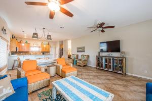 ein Wohnzimmer mit orangefarbenen Möbeln und einem Flachbild-TV in der Unterkunft Casa Chillotta in Mustang Beach