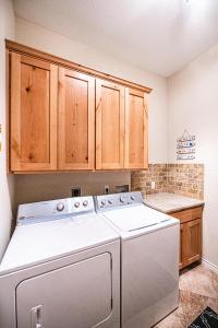 eine Küche mit Waschmaschine und Holzschränken in der Unterkunft Casa Chillotta in Mustang Beach