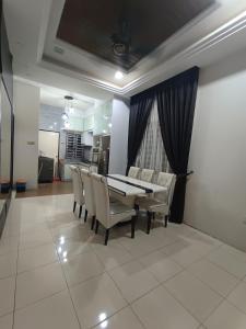 une salle à manger avec une table et des chaises dans l'établissement Homestay Kayangan Gua Musang, à Gua Musang